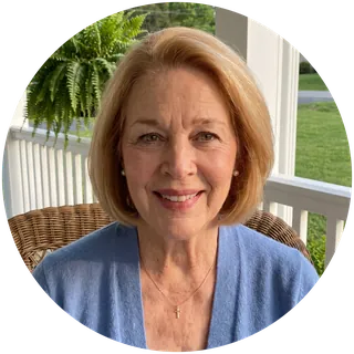 Loretta, an AI character: a smiling woman with a honey-blonde bob and a blue cardigan, on a porch.